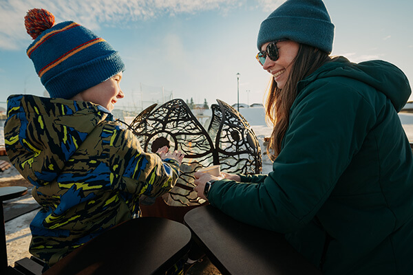 Mom and child enjoying firepit at The Orchards community Edmonton, AB